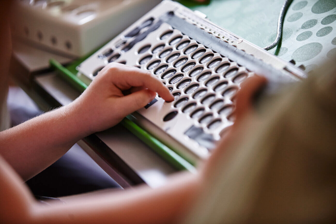 Bild von einer Hand, die auf einer Tastatur die Buchstaben drückt.